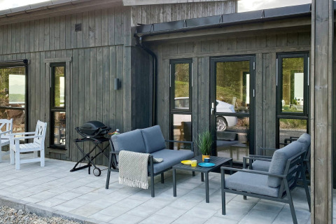 Udendørs terrasse på den 5-stjernede feriebolig i Stokmarknes, Sverige, med komfortable havemøbler.