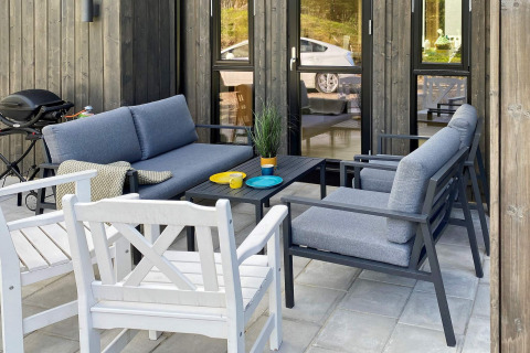 Buitenpatio met moderne zitplaatsen en barbecue bij vijfsterren vakantiehuis in Stokmarknes, Zweden.