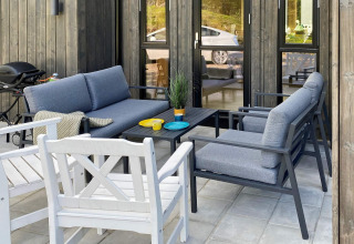 Terrasse extérieure avec sièges modernes et barbecue au gîte 5 étoiles à Stokmarknes, Suède.