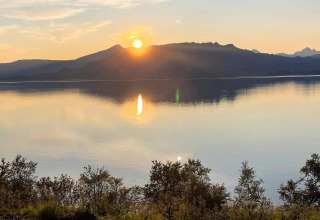 Schitterende zonsondergang boven rustig water en bergen, vanaf lodge '5 star holiday home in stokmarknes' in Zweden