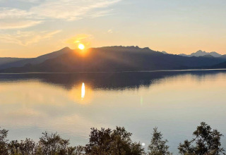 Atardecer sobre un lago tranquilo y montañas, visto desde 5 star holiday home in stokmarknes, Suecia.