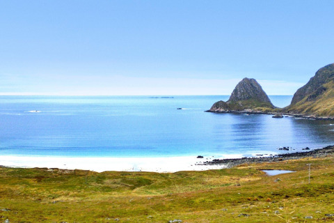 View from 5 star holiday home in Stokmarknes, Sweden overlooking coast, rocky hills, and calm sea.