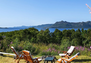 Cinco sillas de madera con vista al lago y montañas en 5 star holiday home in stokmarknes, Suecia.