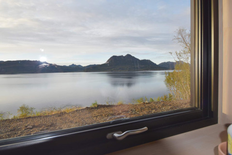 Smuk udsigt over fjord og bjerge gennem et vindue fra «5 star holiday home in stokmarknes» i Sverige.