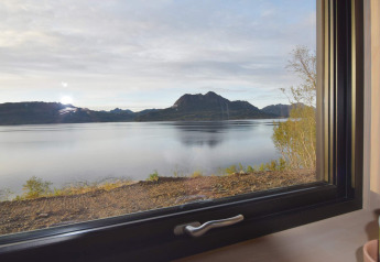 Wunderschöner Ausblick auf See und Berge durch ein Fenster im «5 star holiday home in stokmarknes» in Schweden.