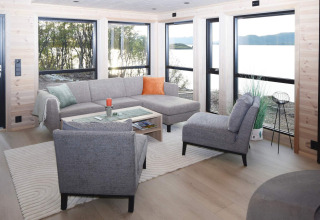 Modernes Wohnzimmer im 5-Sterne-Ferienhaus in Stokmarknes, Schweden, mit großen Fenstern und Seeblick.
