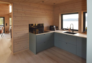 Modern kitchen in 5 star holiday home in Stokmarknes, Sweden, with wood interiors and lake view window.