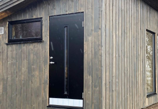 Porta nera con vetro stretto e finestre in casa vacanza 5 star holiday home in Stokmarknes, Svezia, esterno in legno.