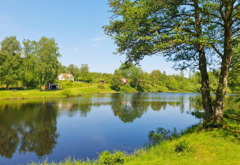 Zicht op een vakantiewoning aan het meer omringd door groen in Karlskrona, Zweden, op een zonnige dag.