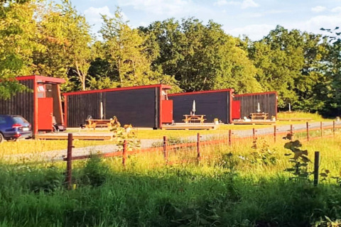 Moderne vakantiehuisjes met rode accenten in KARLSKRONA, te midden van groen en picknicktafels.