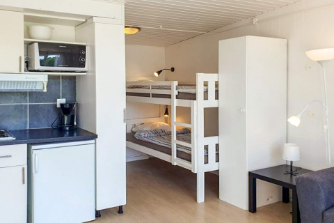 Kompakt hytte i Karlskrona, Sverige, med køkken, køjeseng, garderobe og moderne indretning.