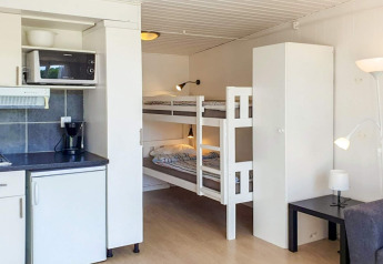 Knusse hut in Karlskrona, Zweden, met kitchenette, stapelbed, garderobekast en moderne inrichting.