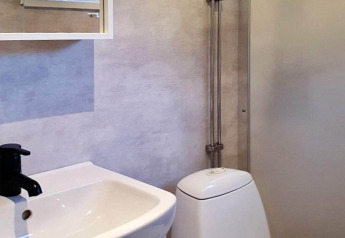 Salle de bain moderne dans une maison de vacances 4 étoiles à Karlskrona, Suède, avec lavabo et toilette ovale.