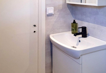 Moderne badeværelsesvask med sort armatur og sæbedispenser i en feriebolig i Karlskrona, Sverige.