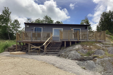 Casa de vacaciones para 4 personas en Nösund con una terraza de madera, escaleras y paisaje rocoso natural.