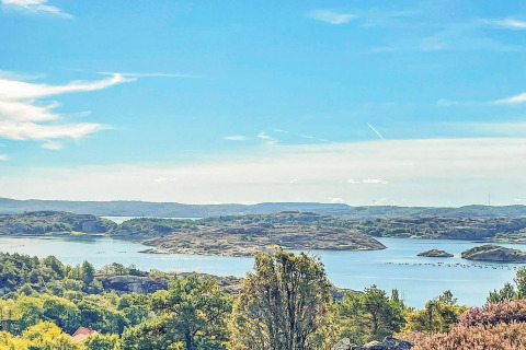 Vue sur les lacs, les îles et la verdure depuis une maison de vacances à Nösund, Suède, sous un beau ciel bleu.