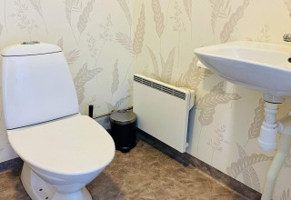 Bagno con WC, lavandino e termosifone in una casa vacanze a Nösund, Svezia, carta da parati.
