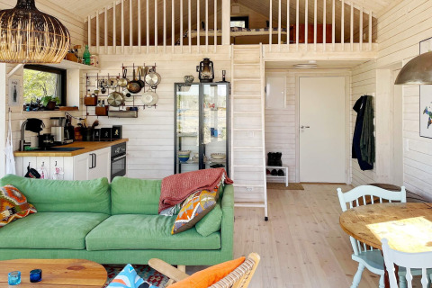 Gezellige vakantiewoning in VÄDDÖ, Zweden, met groene zetel, keuken, eetruimte en slaapzolder.