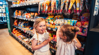 Zwei Kinder stöbern in einem Süßwarenladen auf dem Eurocamping Vessem BV in Nordbrabant, Niederlande.