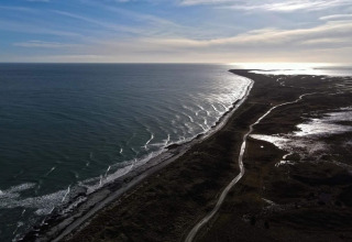 Vue côtière depuis une maison de vacances 5 étoiles à Læsø, Danemark, avec mer et route sinueuse.