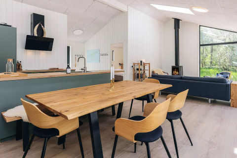 Modernes Wohnzimmer und Küche in einem 5-Sterne-Ferienhaus auf Læsø, Dänemark, mit Holzmöbeln.