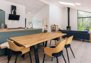 Modern living and kitchen area in a 5 star holiday home in Læsø, Denmark, featuring wood accents and stove.