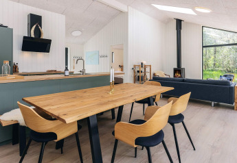 Salón y cocina modernos en una casa de vacaciones de 5 estrellas en Læsø, Dinamarca, con muebles de madera.