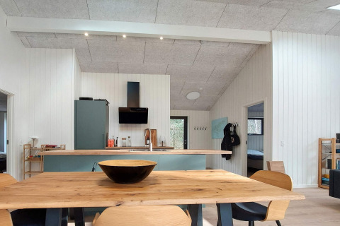 Cucina e sala da pranzo moderne con tavolo in legno in una casa vacanze a Læsø, Danimarca.