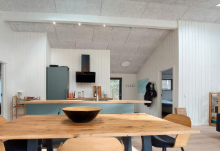 Cuisine et salle à manger modernes avec table en bois dans une maison de vacances à Læsø, Danemark.
