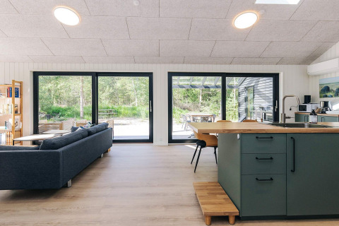 Moderne leefruimte in 5-sterren vakantiewoning op Læsø, Denemarken, met zithoek en zicht op natuur.