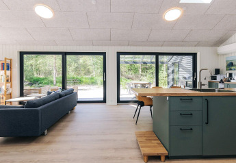 Moderne leefruimte in 5-sterren vakantiewoning op Læsø, Denemarken, met zithoek en zicht op natuur.