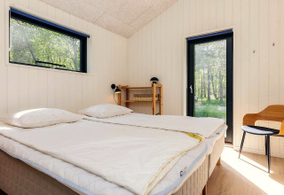 Chambre lumineuse dans une maison de vacances à Læsø, Danemark, avec lit double et vue sur la nature.