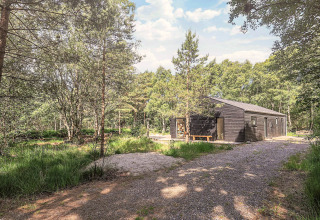 Chalet moderne en bois entouré de forêt et chemin de gravier près d’un gîte 5 étoiles à Læsø, Danemark
