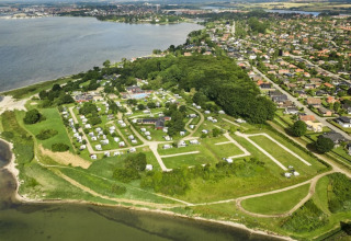 Luftaufnahme vom Horsens City Camp in Dänemark mit Campingplätzen am Wasser und angrenzender Stadt.