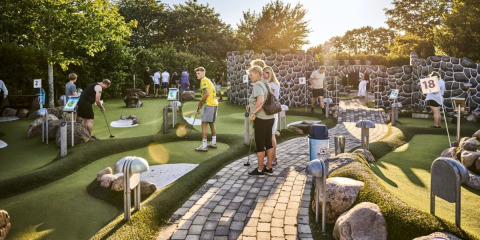 Persone si divertono giocando a minigolf in una giornata soleggiata al Horsens City Camp in Danimarca.