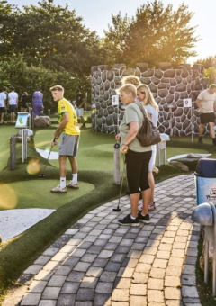 Mensen spelen op een zonnige dag midgetgolf bij Horsens City Camp vakantiepark in Midden-Denemarken.