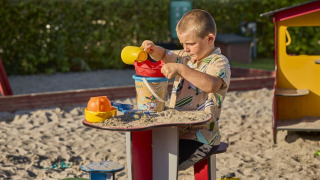 Jongen speelt met zand in de speeltuin van Horsens City Camp, een populair vakantiepark in Midden-Denemarken.