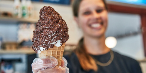 Woman smiling and holding a chocolate-sprinkled ice cream cone at Horsens City Camp in Denmark.
