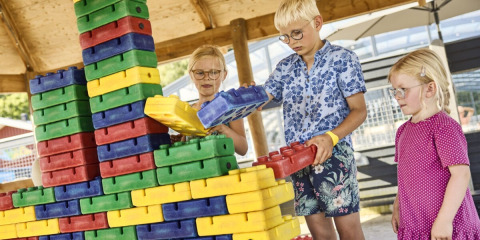 Børn leger med store farverige byggeklodser på Horsens City Camp, en feriepark i Midtjylland, Danmark.