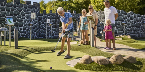 Famiglia che gioca a minigolf al Horsens City Camp, parco vacanze nella regione centrale della Danimarca.