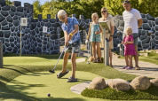Børn og voksne nyder en dag med minigolf på Horsens City Camp feriepark i Region Midtjylland, Danmark.