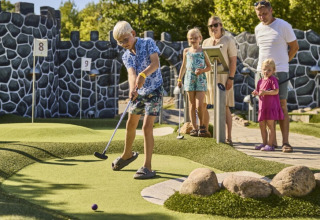 Børn og voksne nyder en dag med minigolf på Horsens City Camp feriepark i Region Midtjylland, Danmark.