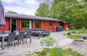 Terrasse eines 8-Personen-Ferienhauses in Holbæk, Dänemark, mit Sitzbereich, Grill und Garten.