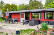 Terrasse avec salle à manger et salon extérieur devant une maison de vacances rouge à Holbæk, Danemark.