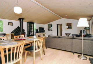 Woonkamer in 8-persoons vakantiewoning in Holbæk, Denemarken met eettafel, houtkachel en moderne inrichting.