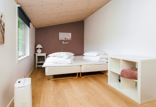 Helles Schlafzimmer mit zwei Einzelbetten und Regal im Ferienhaus in Holbæk, Dänemark.