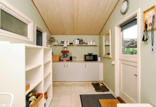 Køkkenområde i feriebolig til 8 personer i Holbæk, Danmark, med hylder, mikroovn og kaffemaskine.