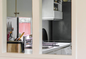 Uitzicht op een moderne keuken met gootsteen, messenhouder en grijze kasten in Holbæk, Denemarken.