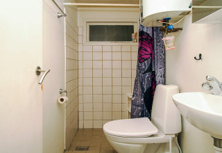 Petite salle de bain de la maison de vacances 8 personnes à Holbæk, Danemark, avec WC, lavabo et douche.