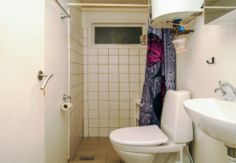 Kleine badkamer in 8-persoons vakantiehuis in Holbæk, Denemarken, met toilet, wastafel en douchegordijn.